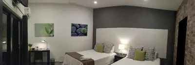 a bedroom with two beds in a room at Hotel Boutique Valverde Santa Elena in San Salvador