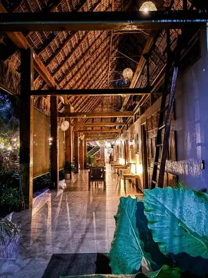 a building with a wooden ceiling with tables and chairs at Hotel Michanti in El Zonte