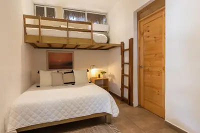 a bedroom with two bunk beds and a door at Hotel Michanti in El Zonte