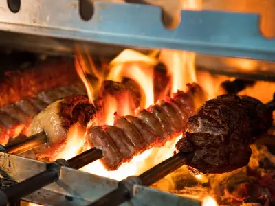 two different types of meat cooking on a grill at Real Intercontinental San Salvador by IHG in San Salvador