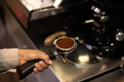 a person holding a coffee pot on a stove at Holiday Inn San Salvador by IHG in San Salvador