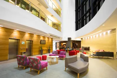 a lobby with colorful chairs and tables in a building at Holiday Inn San Salvador by IHG in San Salvador