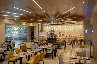 a dining room with tables and chairs and a restaurant at Hilton San Salvador in San Salvador