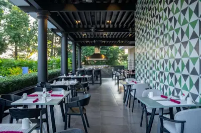 a restaurant with tables and chairs and a wall at Hilton San Salvador in San Salvador