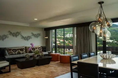 a living room with a table and a dining room at Hilton San Salvador in San Salvador