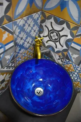 a blue sink with a gold faucet in a bathroom at Hostal Sole in Santa Ana