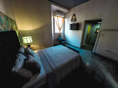 a bedroom with a bed and a lamp and a window at Hostal Sole in Santa Ana