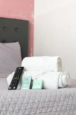 a bed with a remote control and a towel at Hostal Sole in Santa Ana