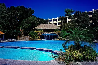 a large swimming pool with a hotel in the background at Sheraton Presidente San Salvador in San Salvador
