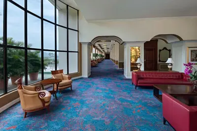 a lobby with red furniture and large windows at Sheraton Presidente San Salvador in San Salvador