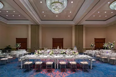 a banquet hall with white tables and chairs and a chandelier at Sheraton Presidente San Salvador in San Salvador