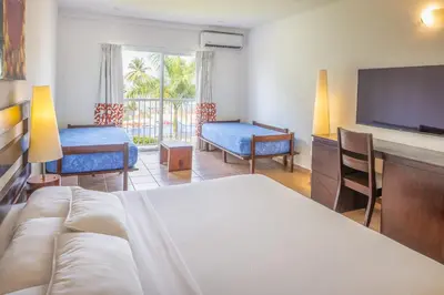a bedroom with a bed and a flat screen tv at Royal Decameron Salinitas - All Inclusive in Los Cóbanos