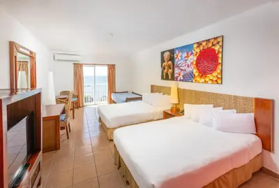 a hotel room with two beds and a flat screen tv at Royal Decameron Salinitas - All Inclusive in Los Cóbanos