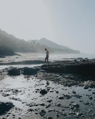 a man walking on the rocks on the beach at Mizata By Antiresort in Santa María Mizata