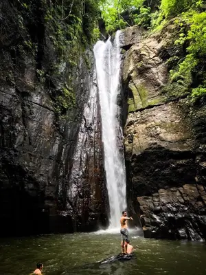two people in the water in front of a waterfall at Mizata By Antiresort in Santa María Mizata