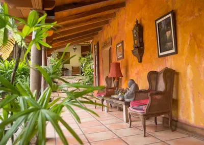 a porch of a house with chairs and a table at Los Almendros de San Lorenzo in Suchitoto