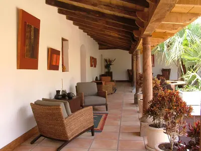 a lobby with chairs and tables in a building at Los Almendros de San Lorenzo in Suchitoto