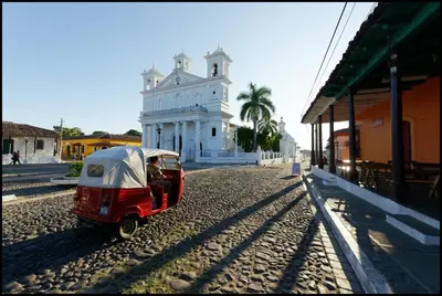 a small red car parked in front of a building at Los Almendros de San Lorenzo in Suchitoto