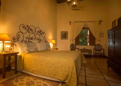 a bedroom with a bed and a table and a window at Los Almendros de San Lorenzo in Suchitoto