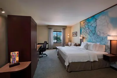 a hotel room with a large bed and a desk at Courtyard by Marriott San Salvador in San Salvador