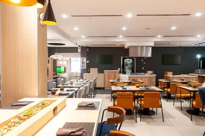 a restaurant with tables and chairs and a cafeteria at Courtyard by Marriott San Salvador in San Salvador