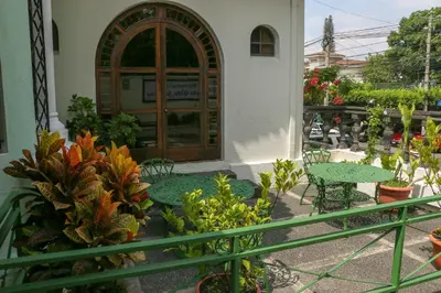 a patio with a table and chairs and plants at Hotel Villa Serena Escalon in San Salvador