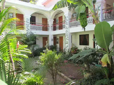 a large white building with plants in front of it at Hotel Villa Serena Escalon in San Salvador