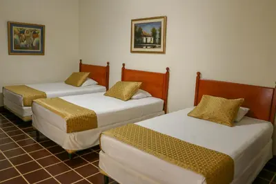 three beds sitting in a room with a tiled floor at Hotel Villa Serena Escalon in San Salvador