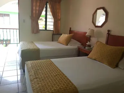 a hotel room with two beds and a mirror at Hotel Villa Serena Escalon in San Salvador