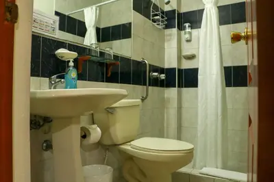 a bathroom with a toilet and a sink and a shower at Hotel Villa Serena Escalon in San Salvador