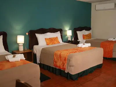 a hotel room with three beds and two lamps at Eco Hotel Mariscal in San Salvador