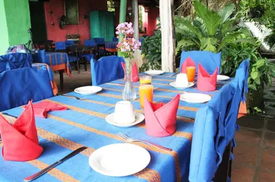 a blue table with red napkins and plates on it at La Posada de Suchitlan in Suchitoto