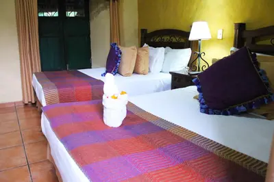 a hotel room with two beds with towels on them at La Posada de Suchitlan in Suchitoto