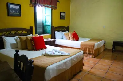 a hotel room with two beds in a room at La Posada de Suchitlan in Suchitoto