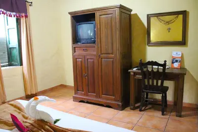 a room with a tv and a wooden entertainment center at La Posada de Suchitlan in Suchitoto