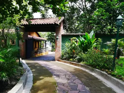 a walkway leading to a house with a brick gate at La Posada de Suchitlan in Suchitoto