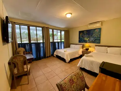 a bedroom with two beds and a table and chairs at Morrison Hotel San Salvador in San Salvador