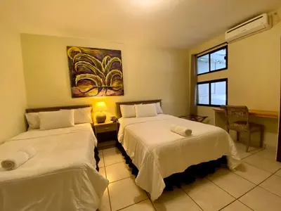 a hotel room with two beds and a window at Morrison Hotel San Salvador in San Salvador