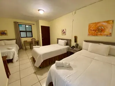 a hotel room with two beds with white sheets at Morrison Hotel San Salvador in San Salvador