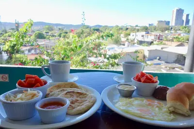 a table with a plate of breakfast food on it at Morrison Hotel San Salvador in San Salvador