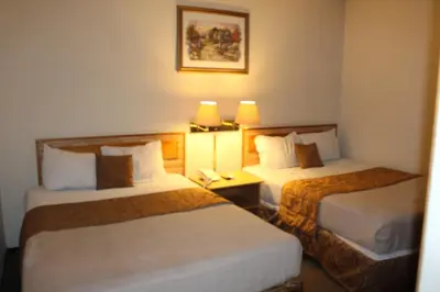 a hotel room with two beds and a telephone at Hotel Mediterraneo Plaza in San Salvador