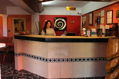 a woman standing behind a bar in a restaurant at Hotel Mediterraneo Plaza in San Salvador