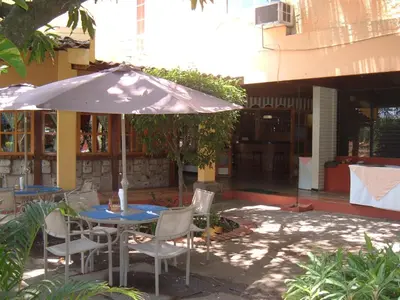 a patio with a table and chairs and an umbrella at Hotel Mediterraneo Plaza in San Salvador