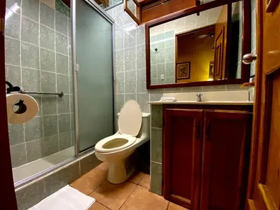 a bathroom with a toilet and a sink and a mirror at El Tejado in Suchitoto