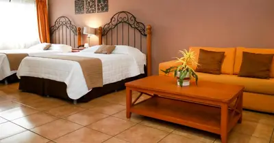 a hotel room with two beds and a couch at Las Magnolias Hotel Boutique in San Salvador