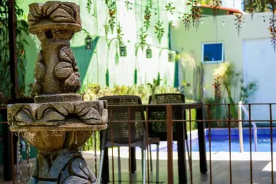 a stone fountain with chairs and a table in a patio at Las Magnolias Hotel Boutique in San Salvador