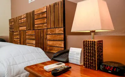 a bed with a lamp on a table next to a bed at Las Magnolias Hotel Boutique in San Salvador