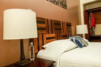 a bedroom with a bed and a lamp on a table at Las Magnolias Hotel Boutique in San Salvador