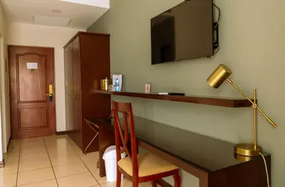 a hotel room with a desk with a chair and a television at Hotel Mirador Plaza in San Salvador