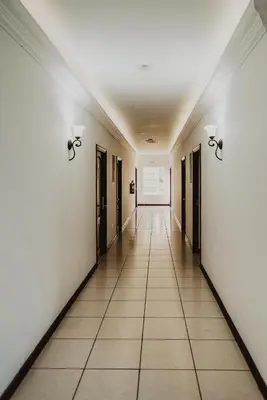 an empty hallway with white walls and doors at Hotel Mirador Plaza in San Salvador
